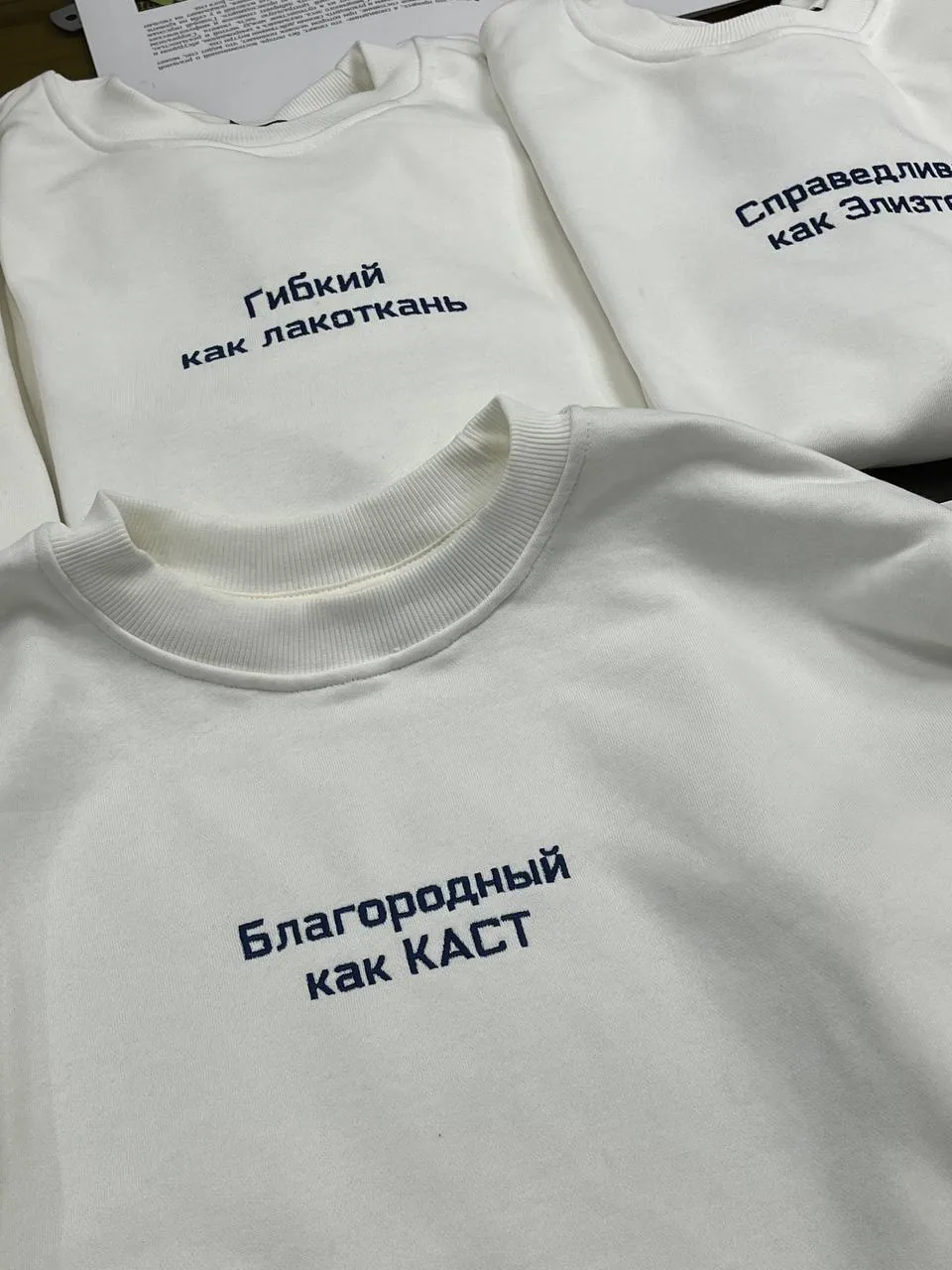 Белые свитшоты с надписями «Гибкий как лакоткань» и «Благородный как КАСТ»
